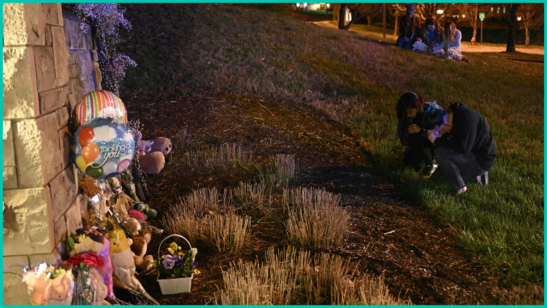 People gather at a makeshift memorial for victims outside the Covenant School building in Nashville, TN.