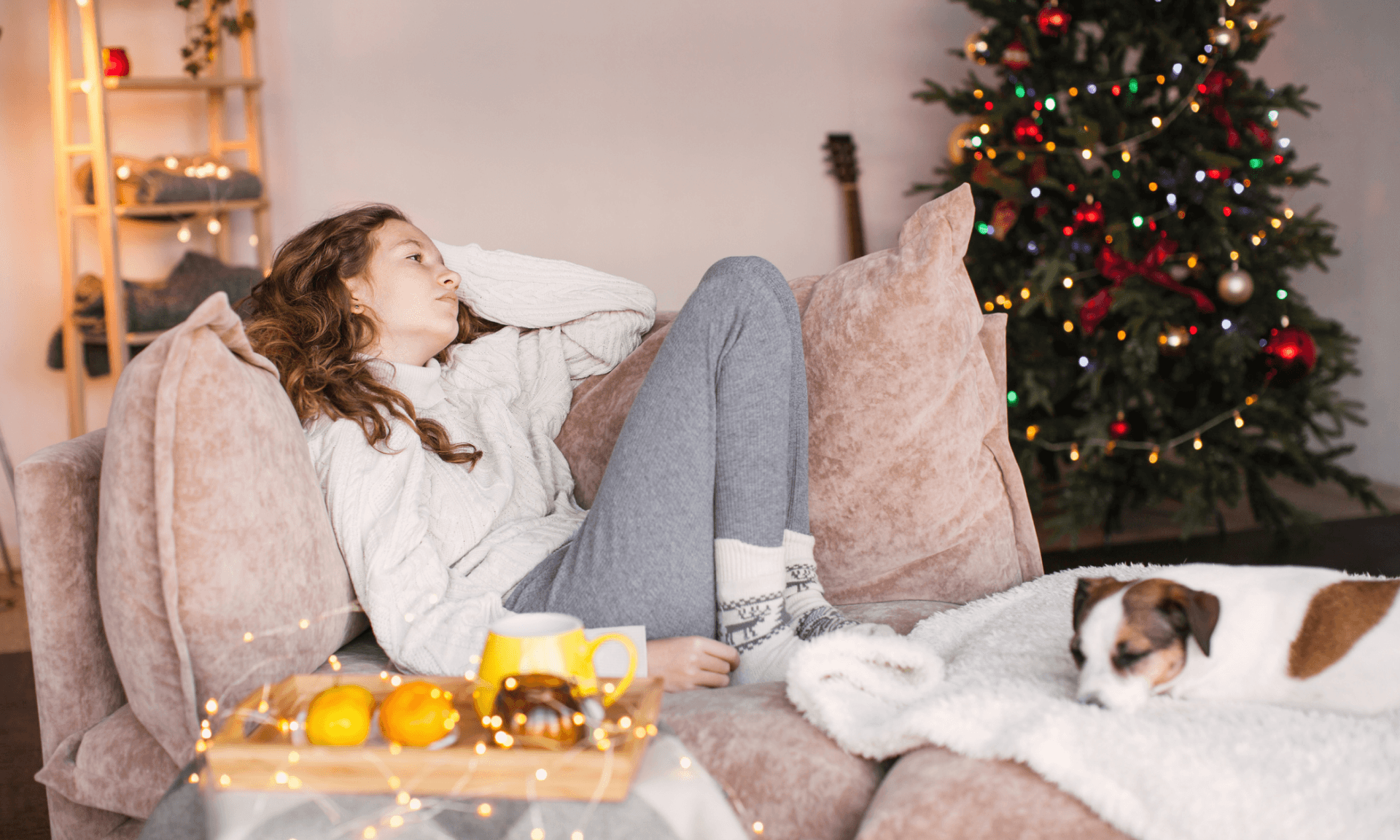 Woman laying on couch with Christmas tree