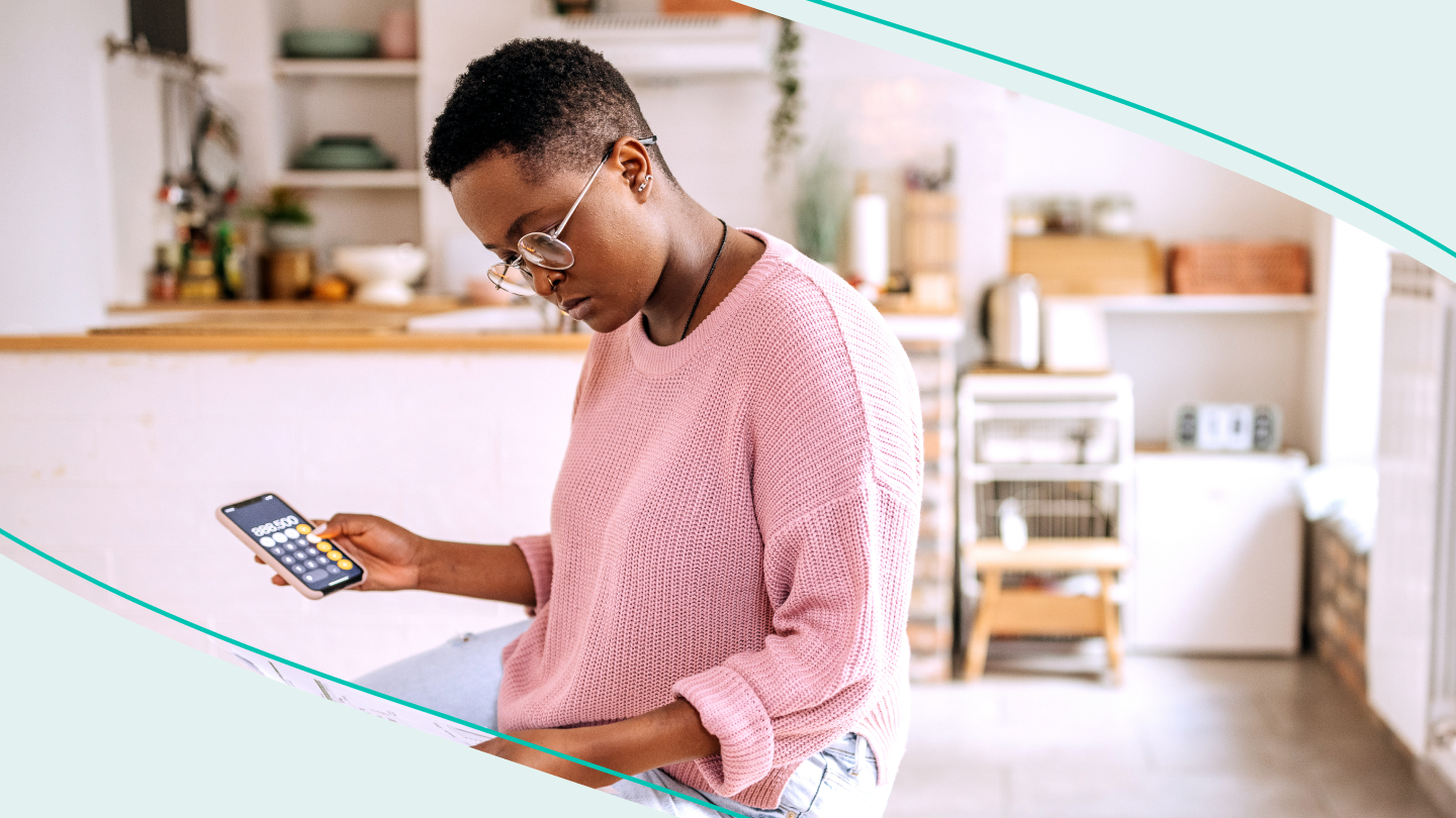 A woman looking at a student loan statement and using a calculator