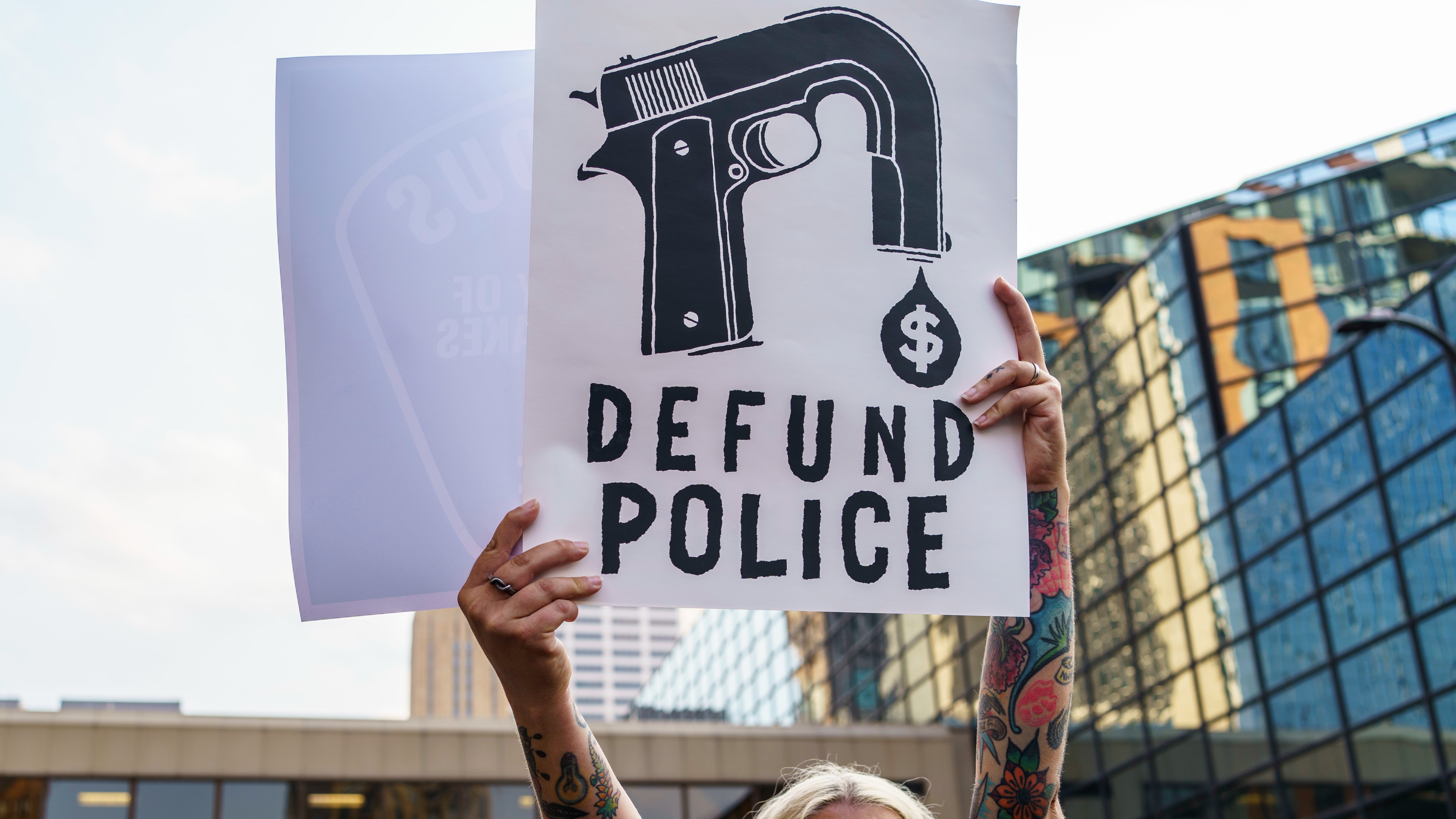 A protester hold a sign reading "Defund the Police" during a demonstration against police brutality and racism in Minneapolis, Minnesota.