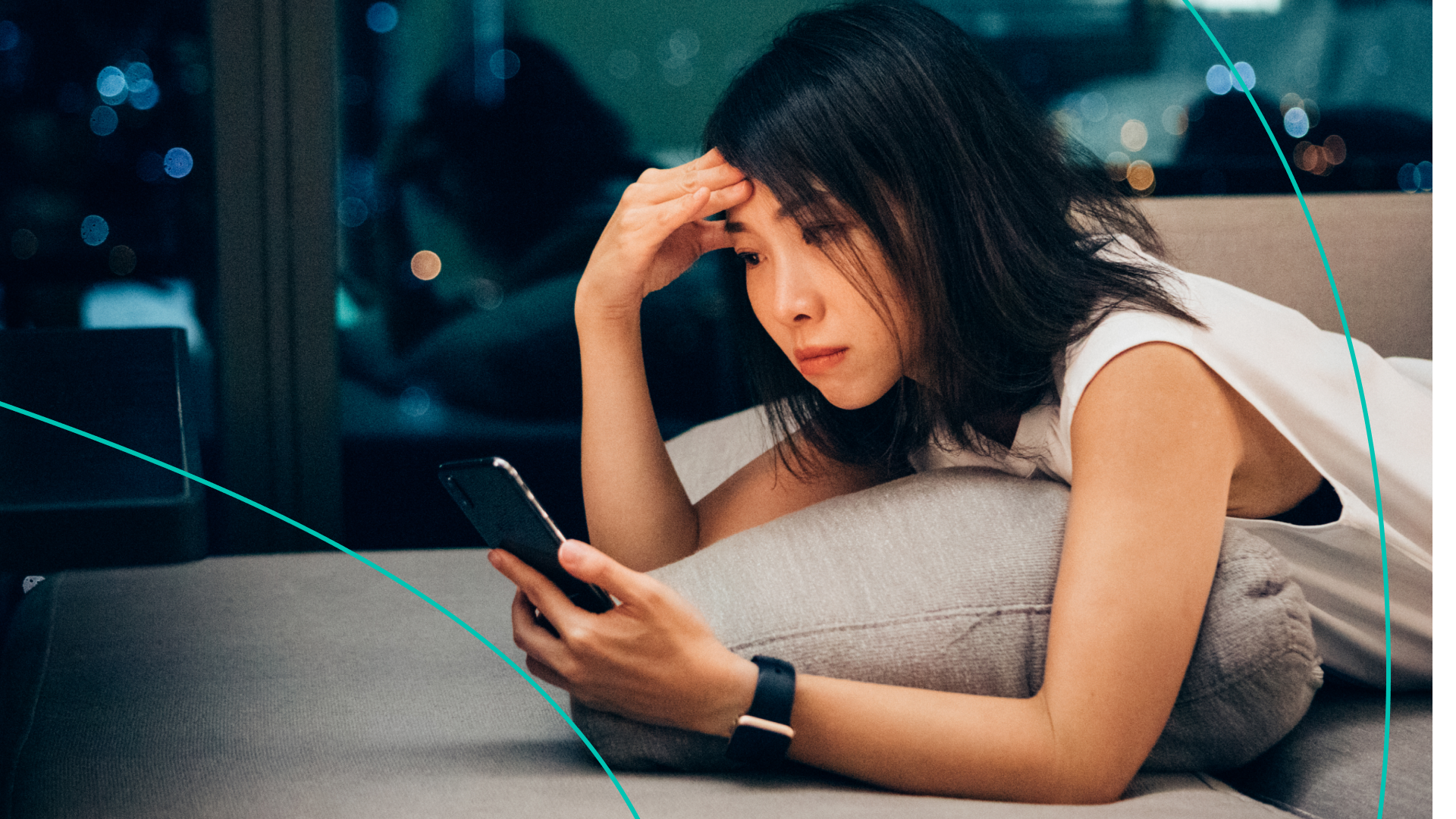 Woman staring at cell phone on couch 