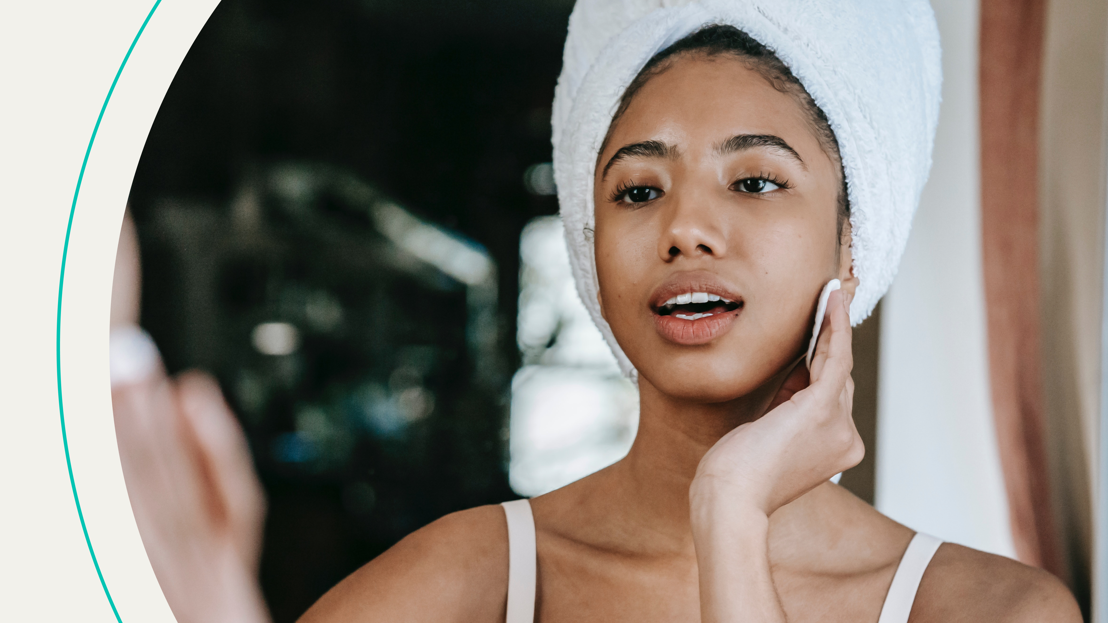 A woman rubbing a cotton round over her face