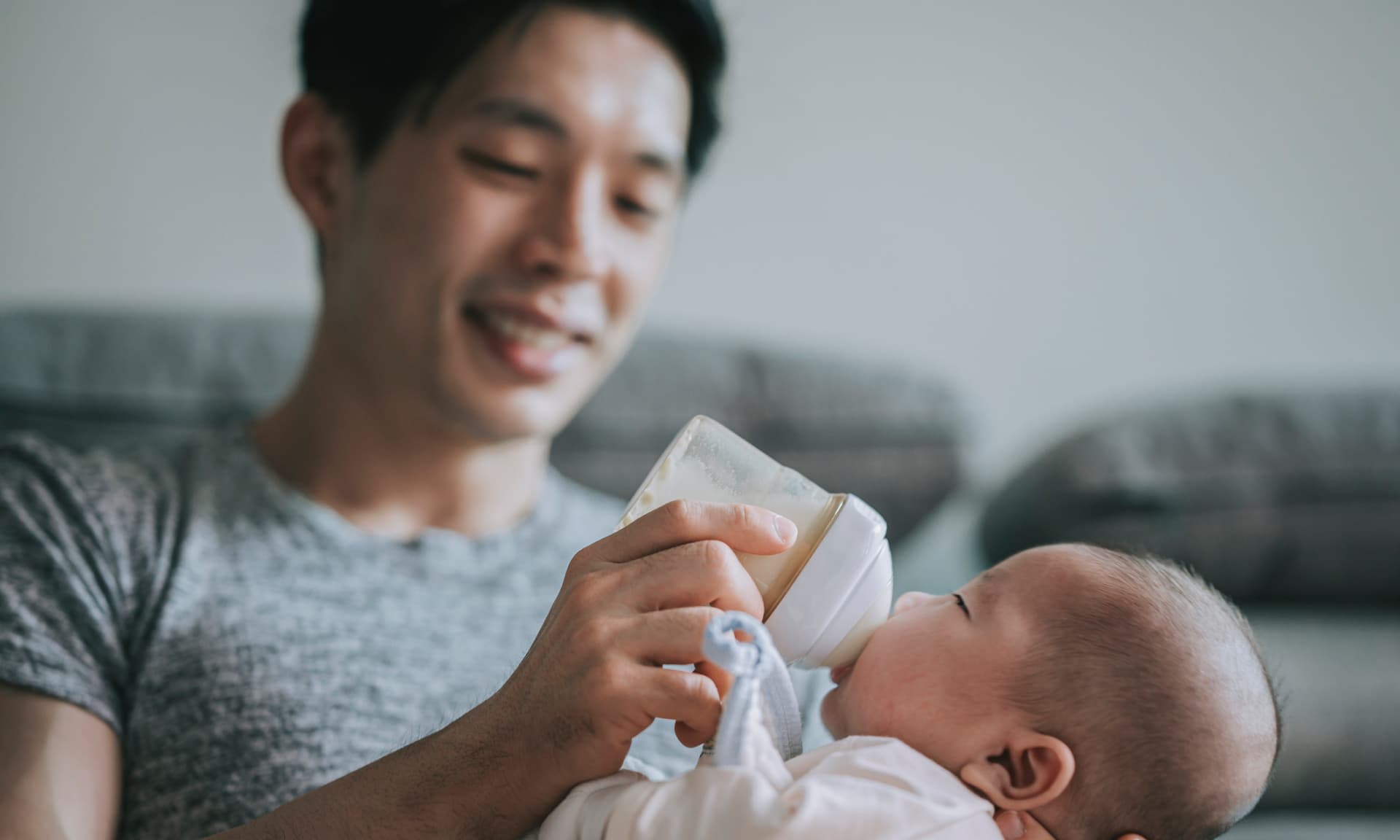 dad giving newborn baby bottle