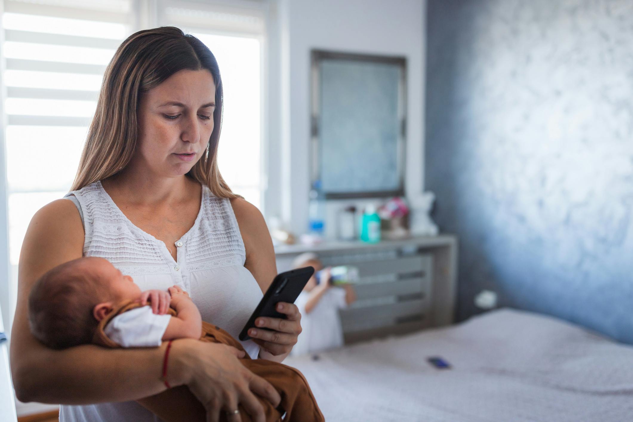 woman with baby looking at phone