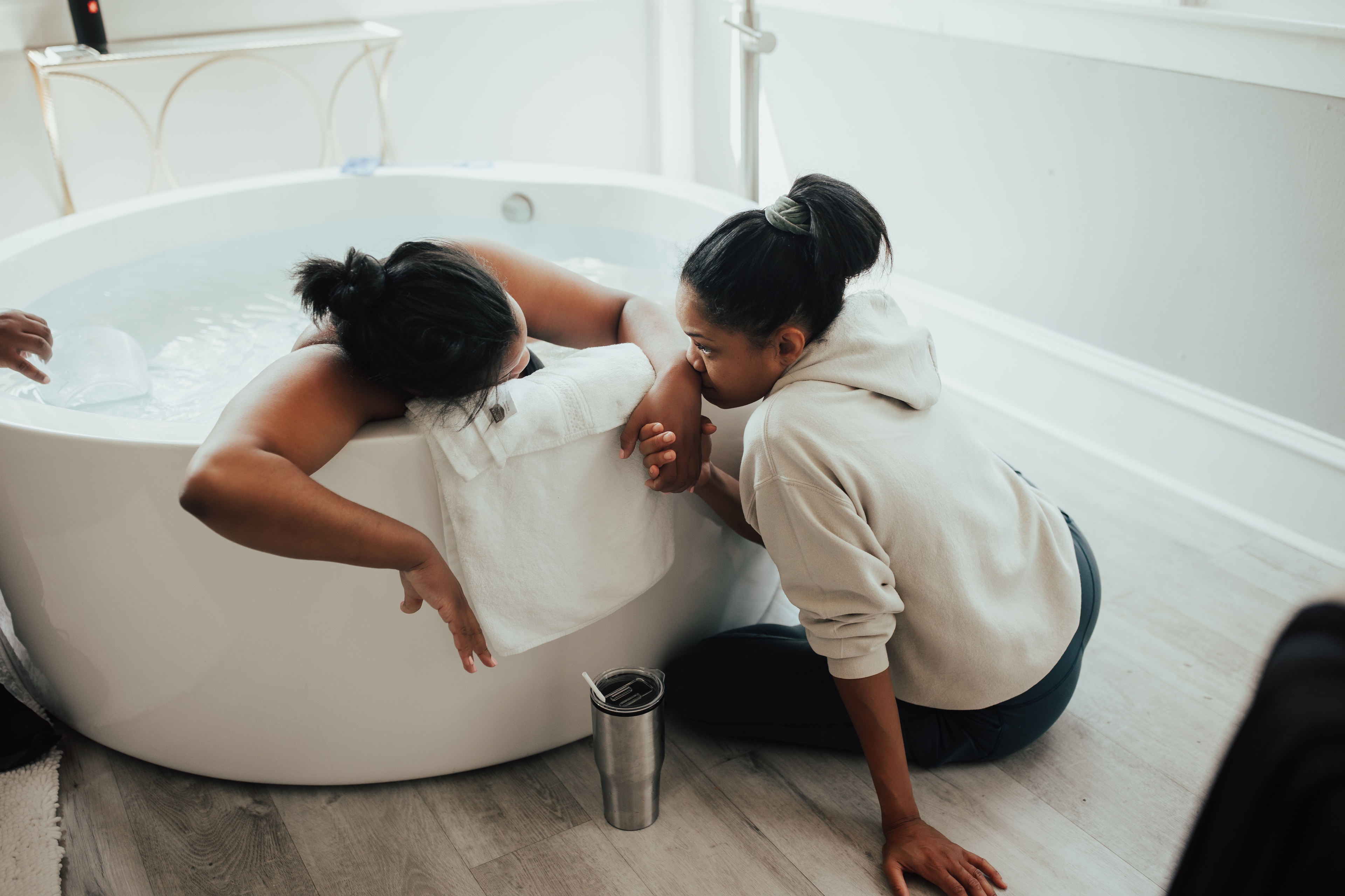 Black Doula Eve Akins helping a woman in labor.