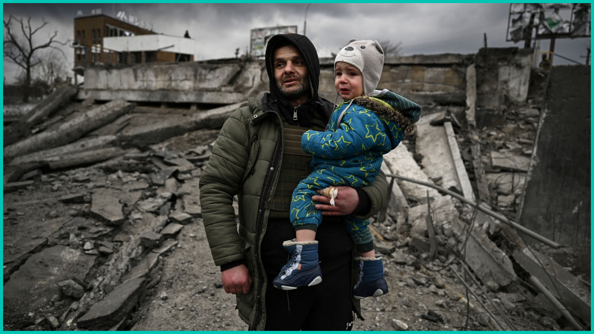 A man holds a child as he flees the city of Irpin
