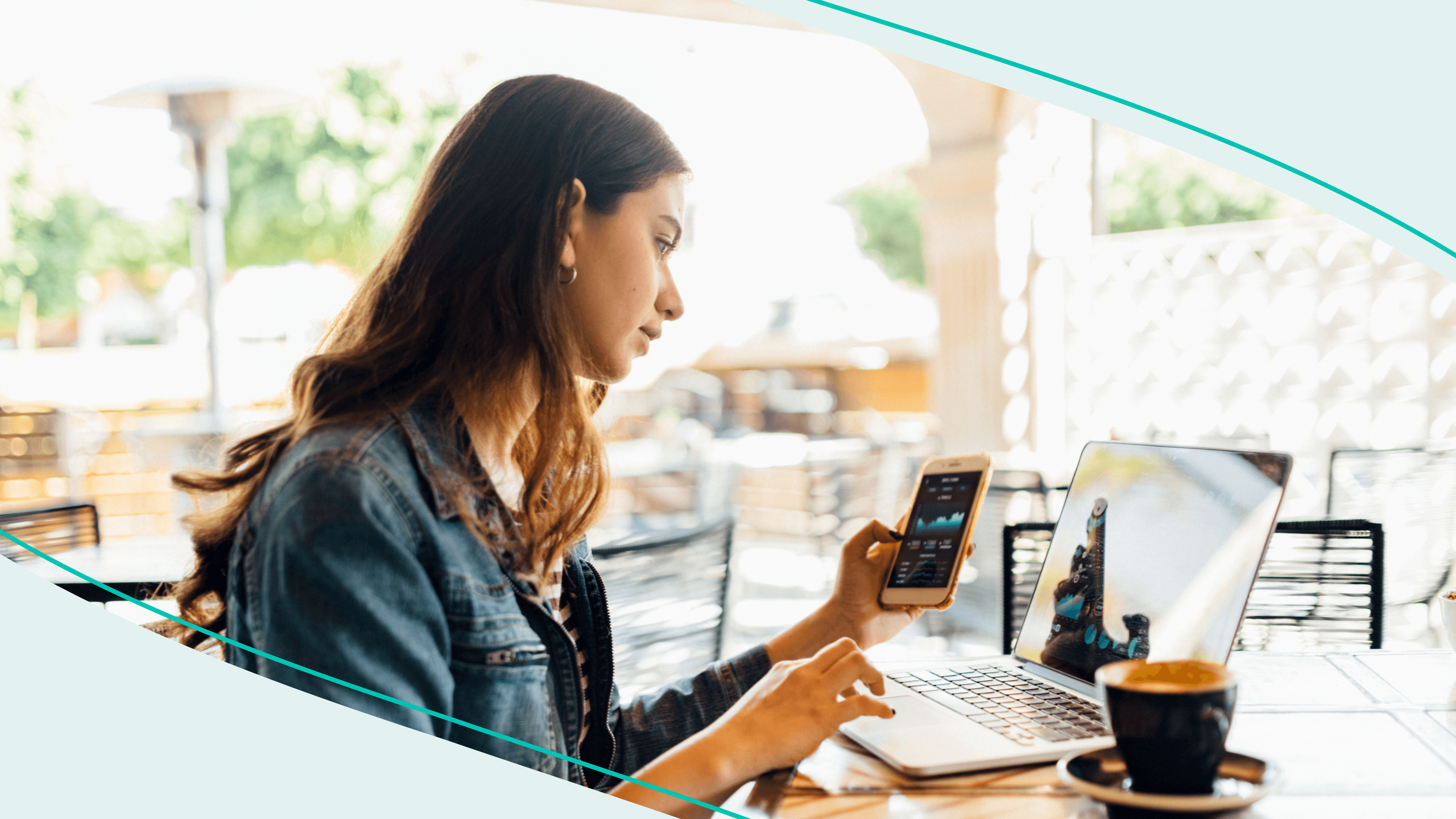 woman checking her phone in front of laptop with coffee