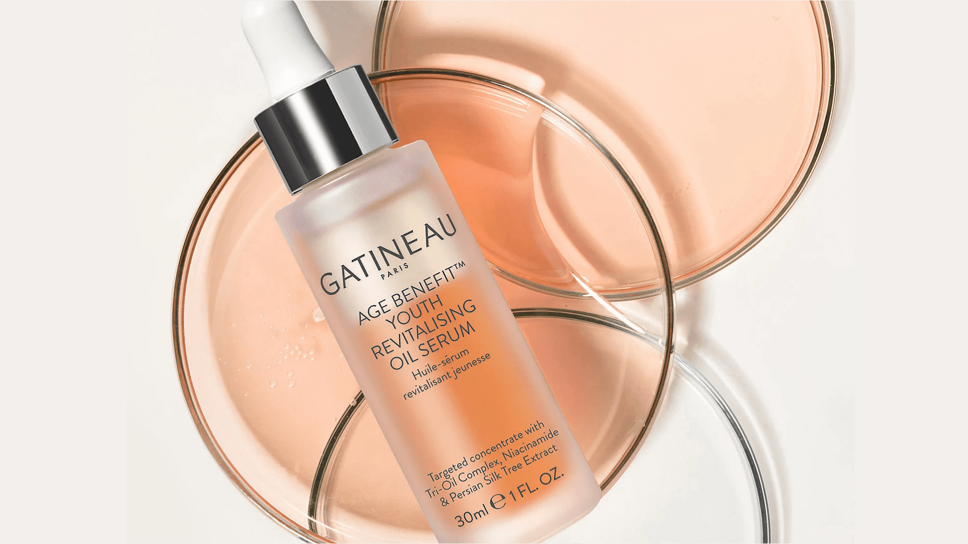 Glass serum bottle on circles of oil