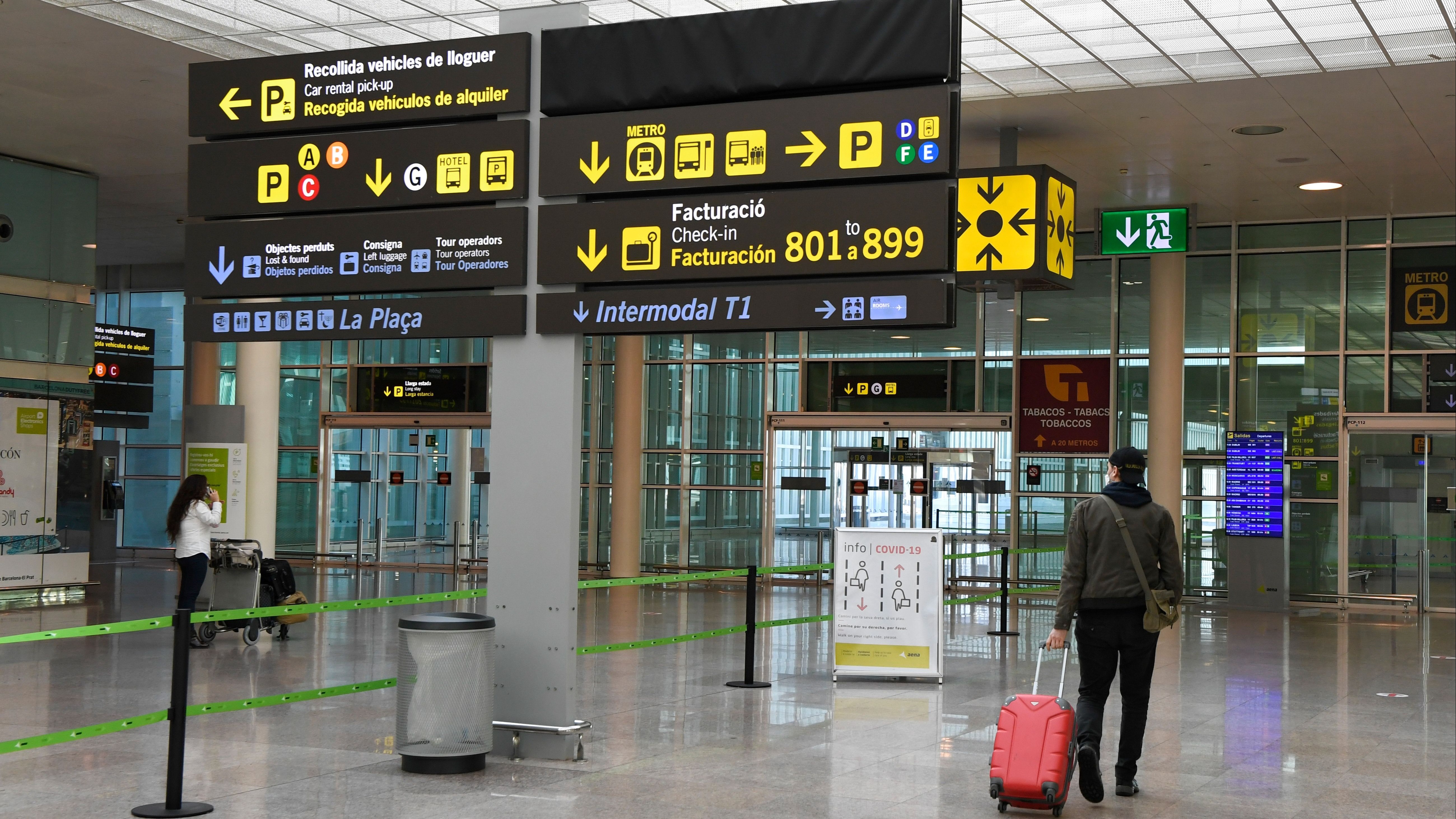A passenger walks at the Terminal 1 of El Prat airport in Barcelona on November 19, 2020 as authorities prepare to transfer all activity from Terminal 2 with travel staying limited amid the coronavirus pandemic.