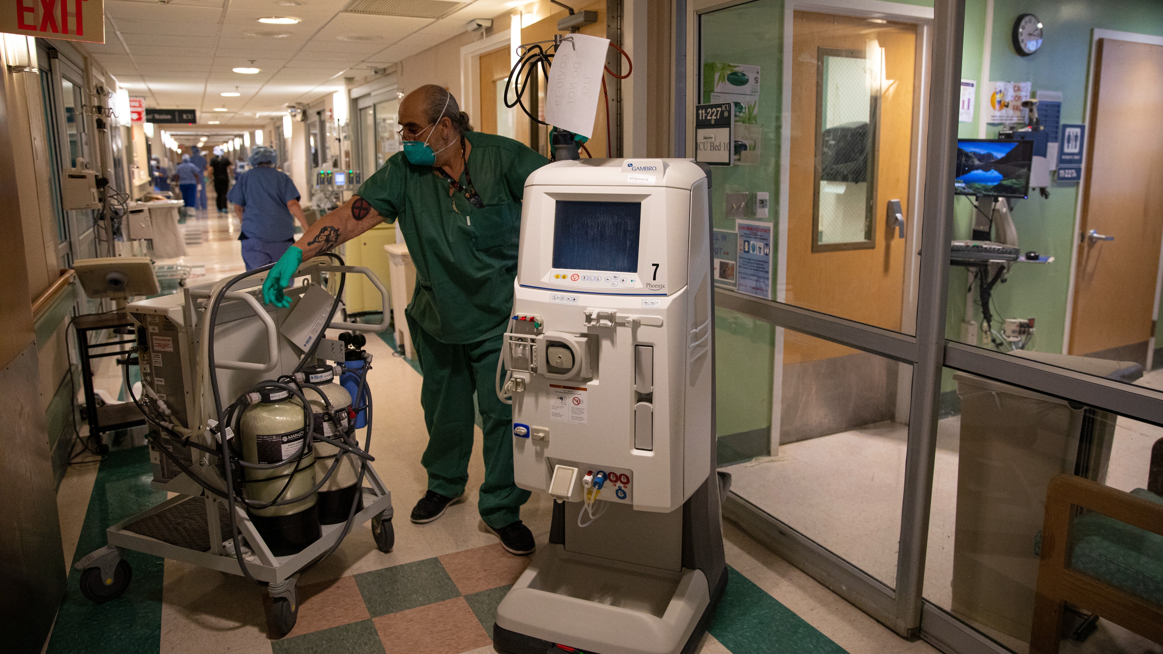 A portable kidney dialysis machine is moved by a hospital staff member