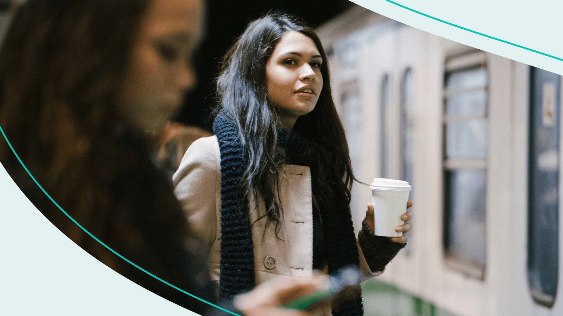 Woman waiting for train while holding a coffee cup