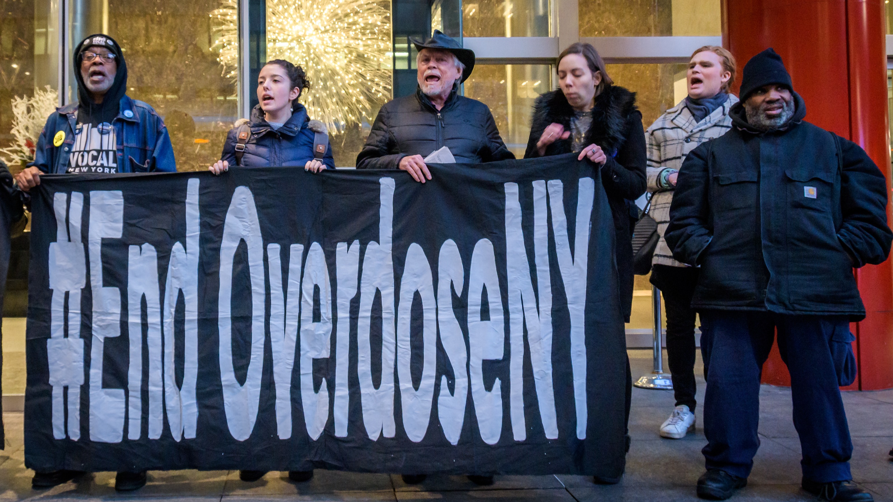 Protesters holding banners blocking access to the building in an act of civil disobedience.