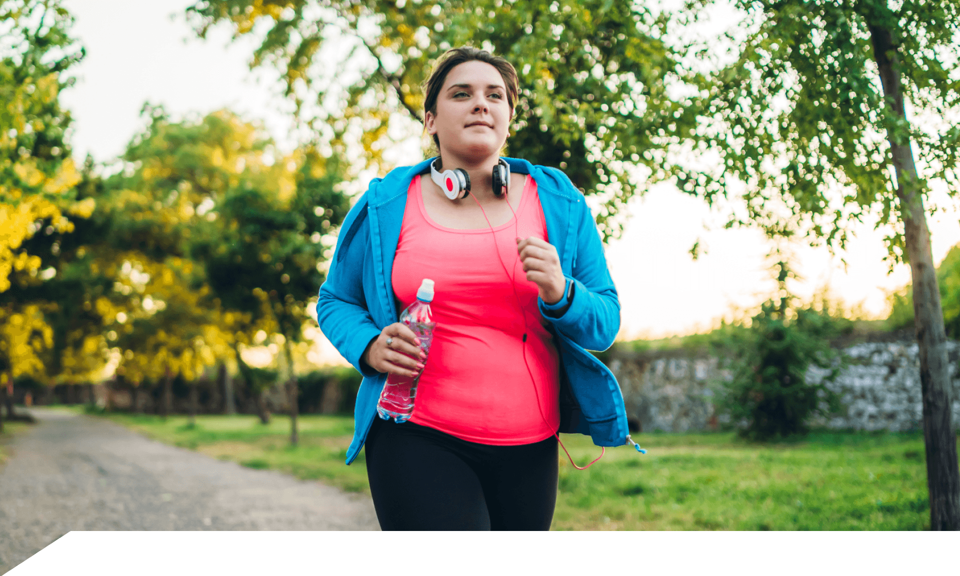 A woman walking in a park wearing workout clothes