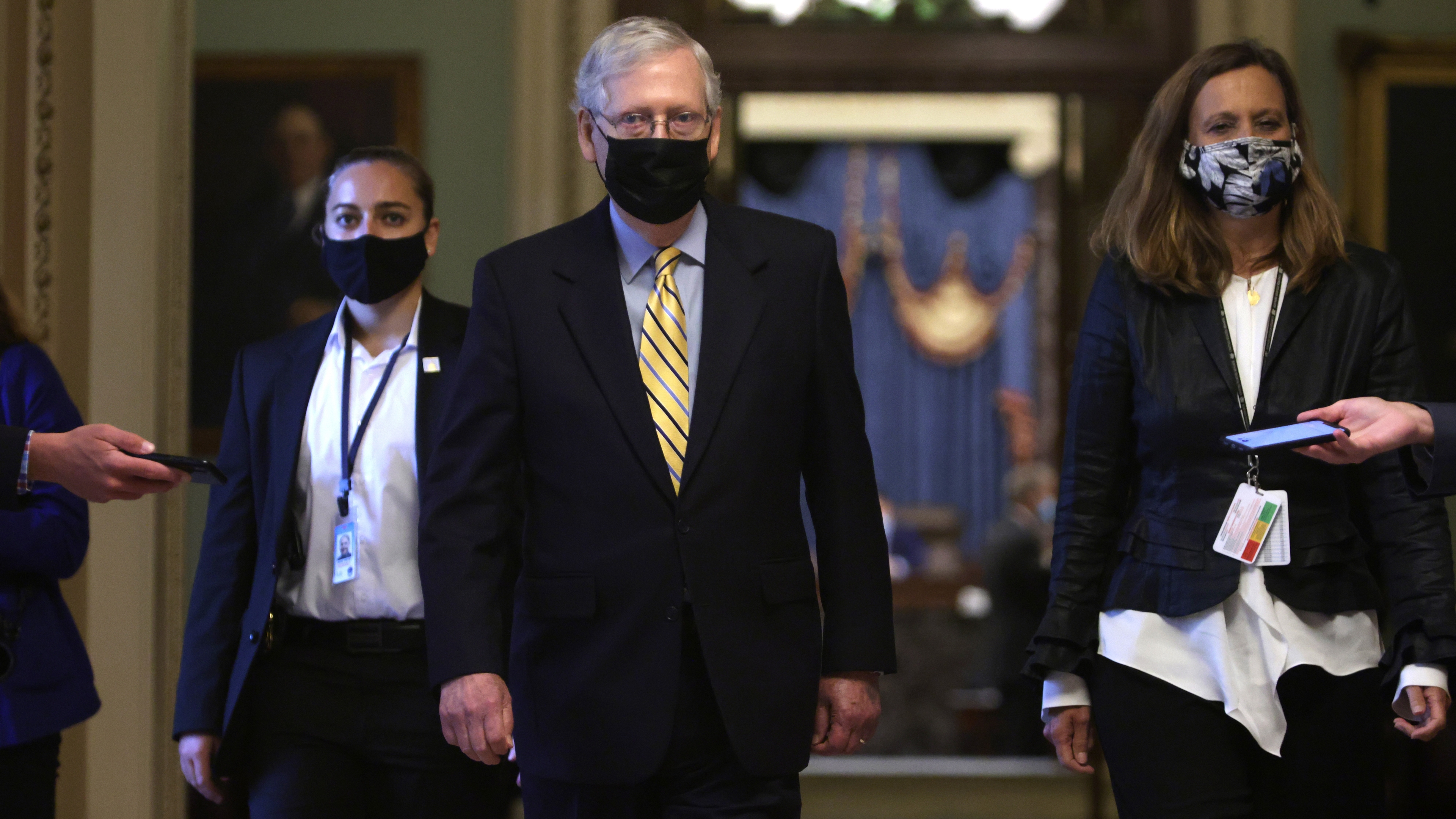 Mitch McConnell walking with a mask