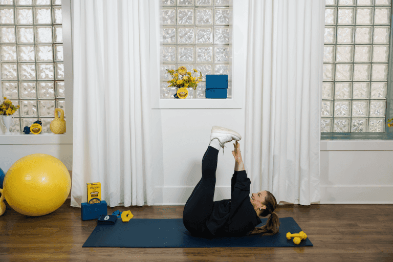 Shawn Johnson East demonstrating toe touch as part of at-home workout