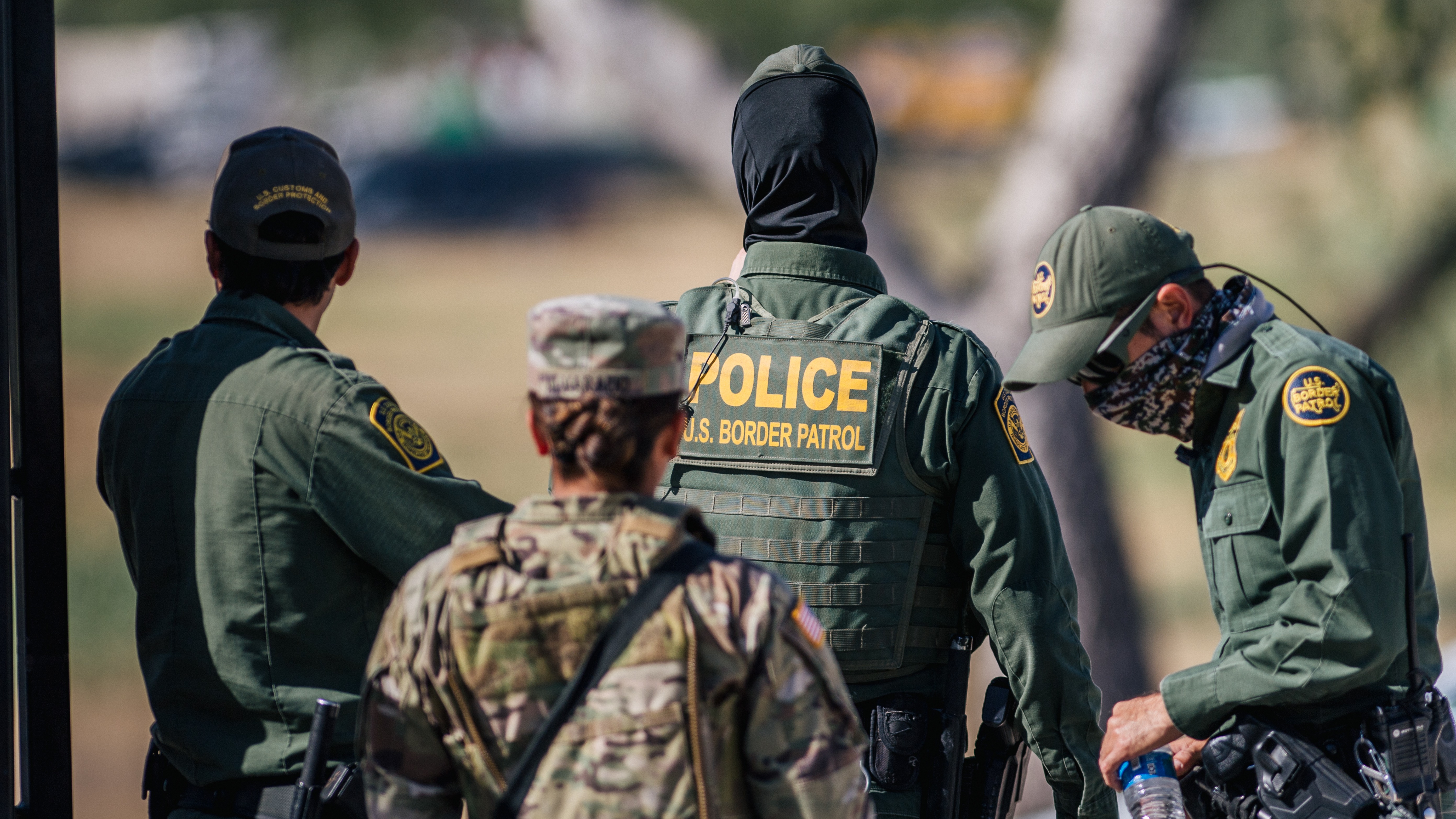 Border Patrol agents and members of the National Guard patrol a checkpoint entry near the Del Rio International Bridge