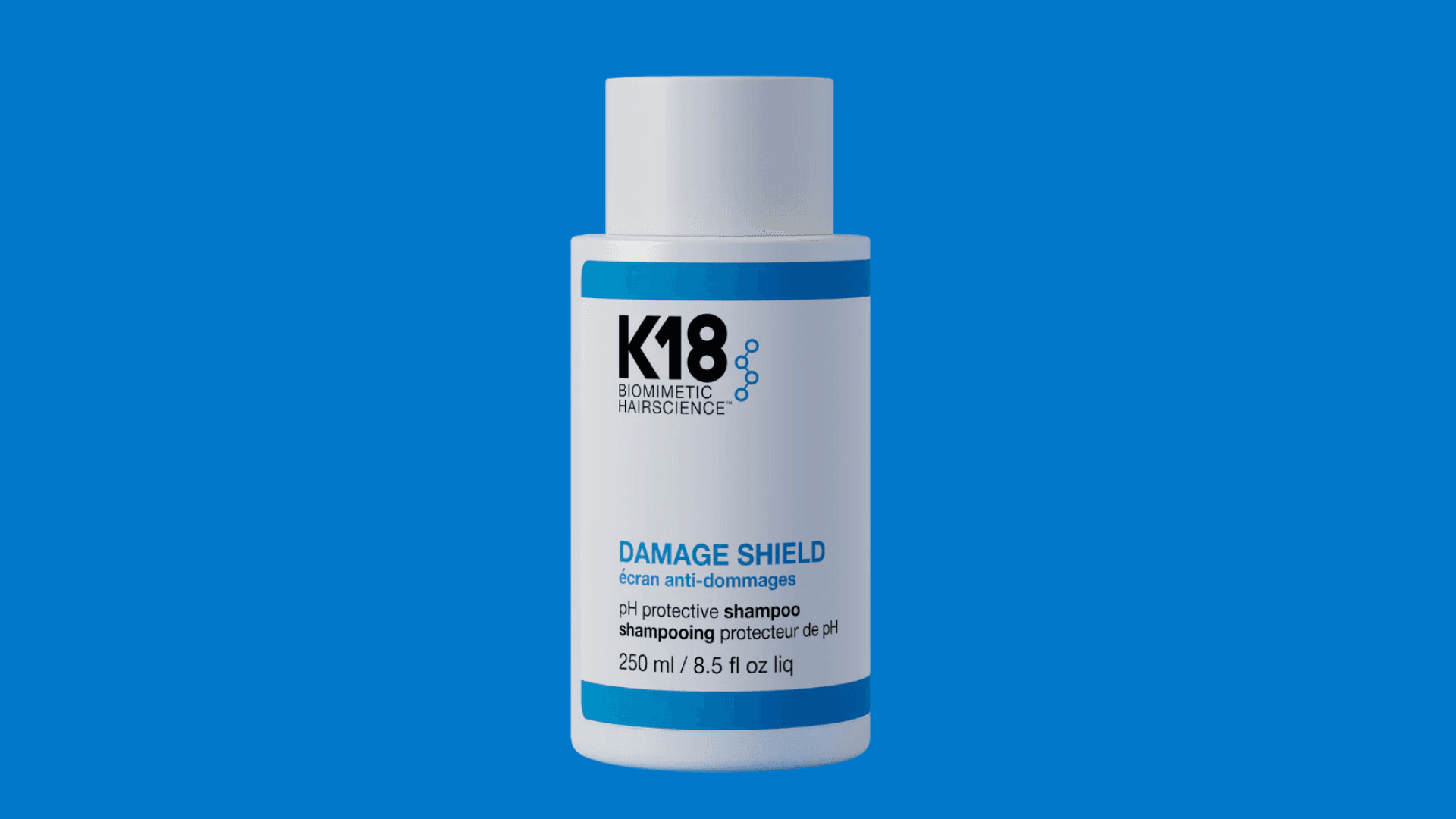 K18 Damage Shield Shampoo bottle on bright blue background