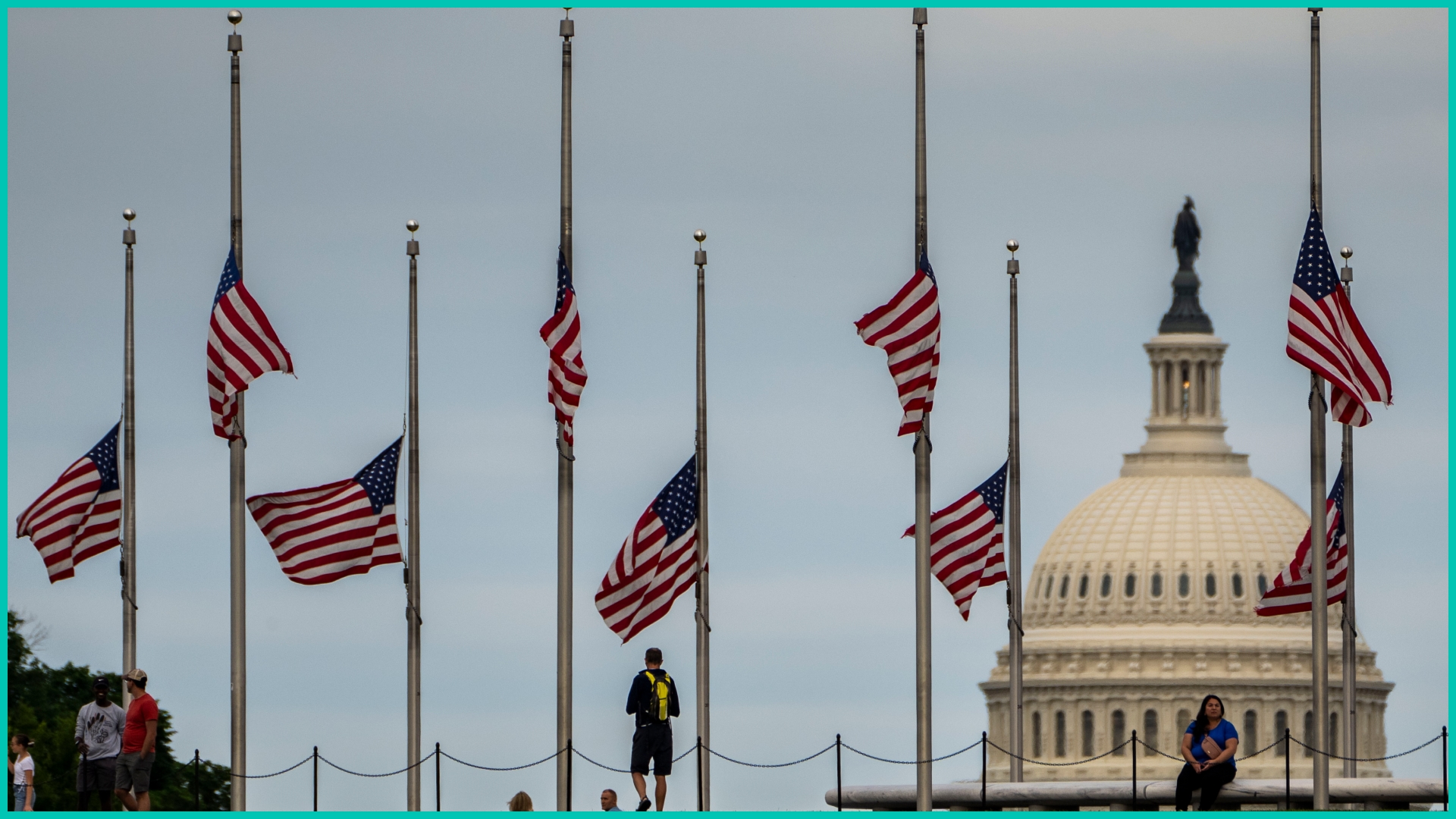 American flags are seen at half-staff surrounding the Washington Monument as people enjoy the weather on the National Mall on Wednesday, May 25, 2022 in Washington, DC.