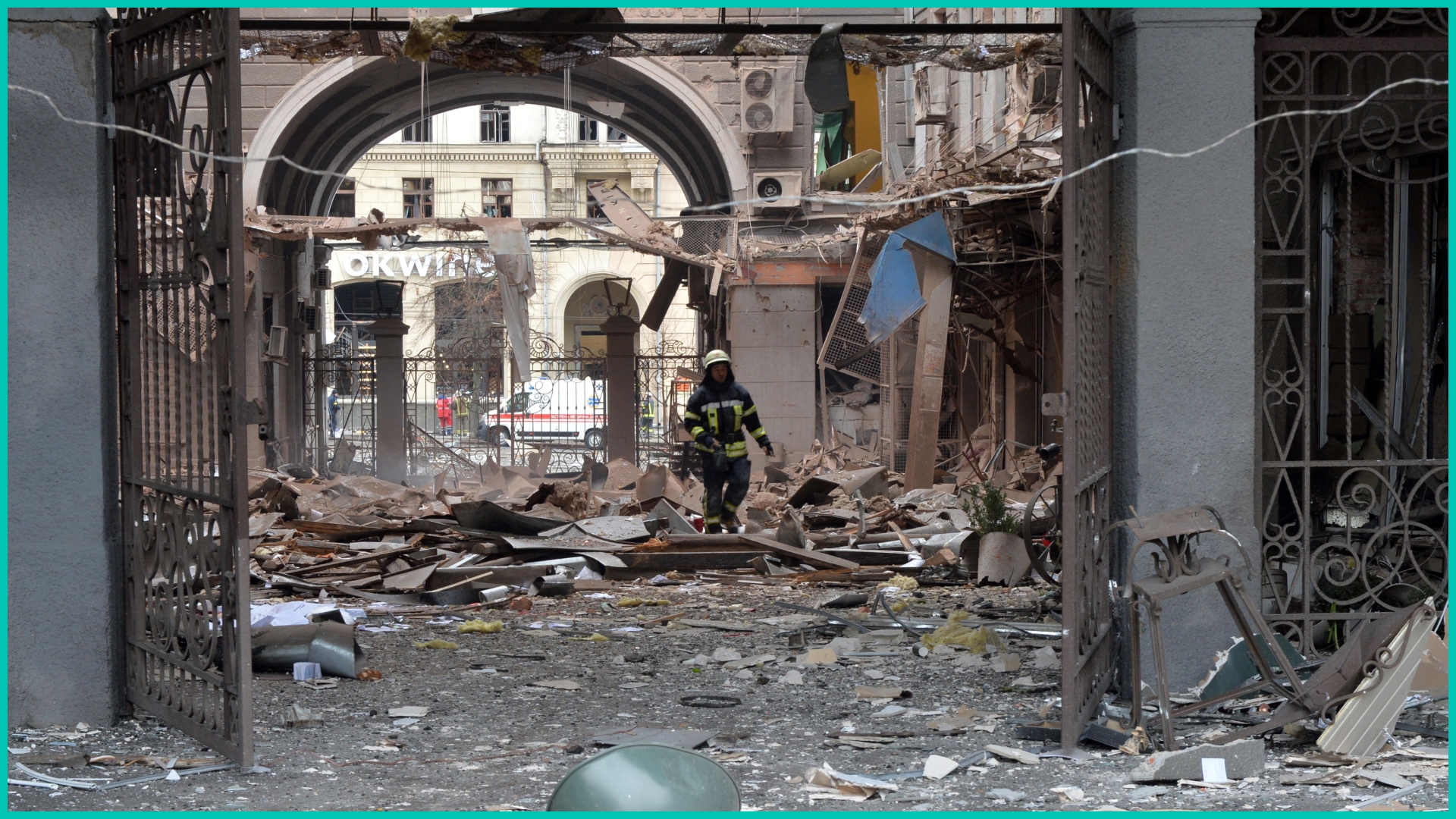 A firefighter walks among damages in a building entrance after the shelling by Russian forces of Constitution Square in Kharkiv