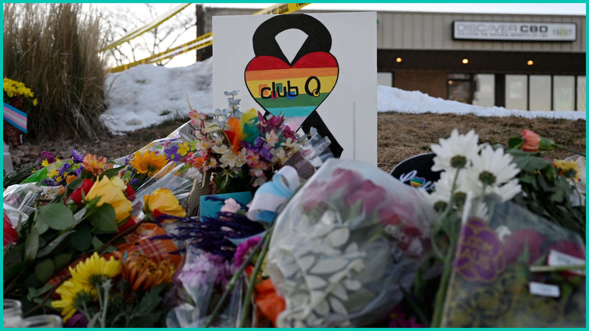People leaves flowers and other items at a memorial near Club Q