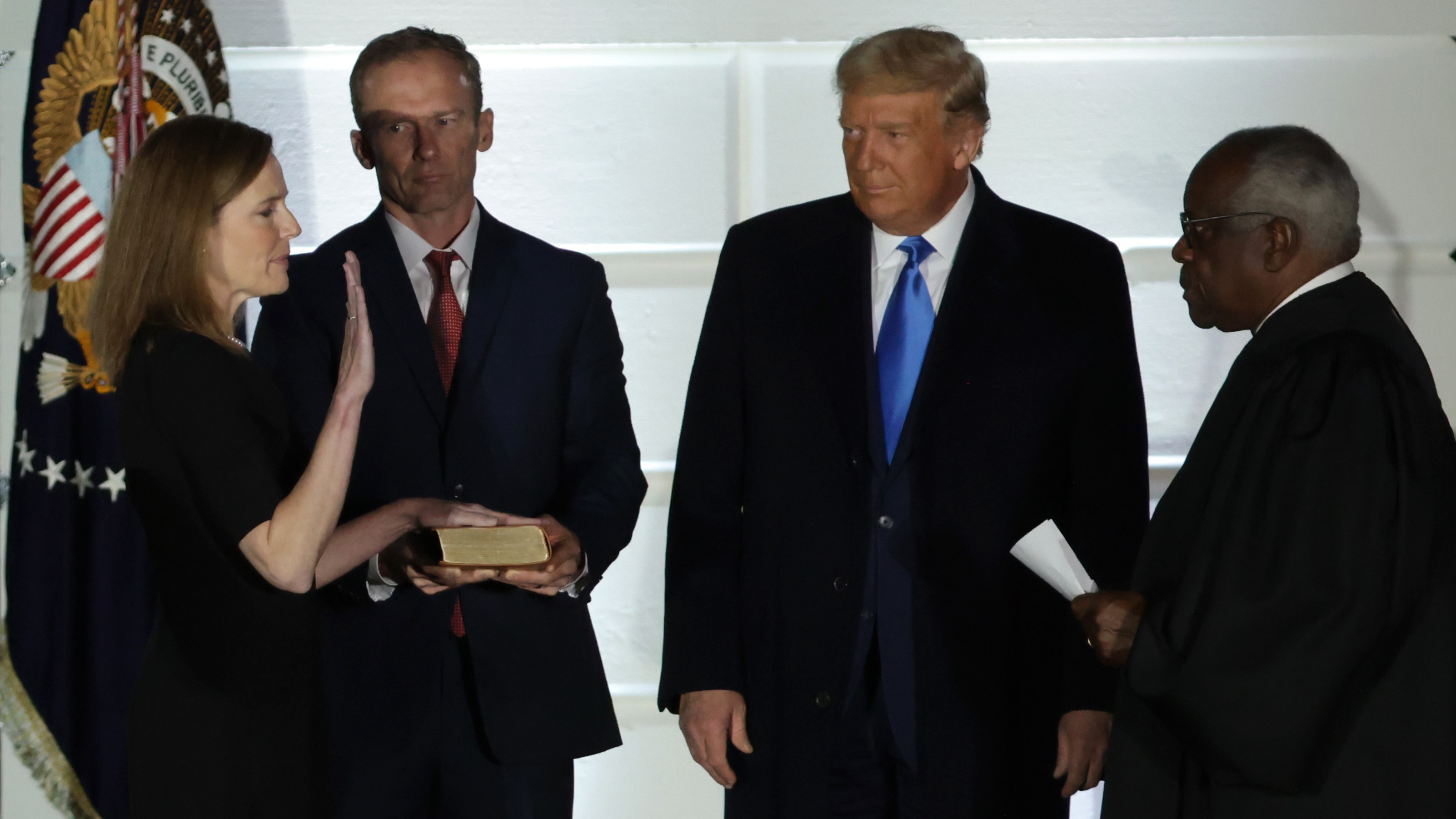 U.S. President Donald Trump watches as U.S. Supreme Court Associate Justice Amy Coney Barrett is sworn in by Supreme Court Associate Justice Clarence Thomas