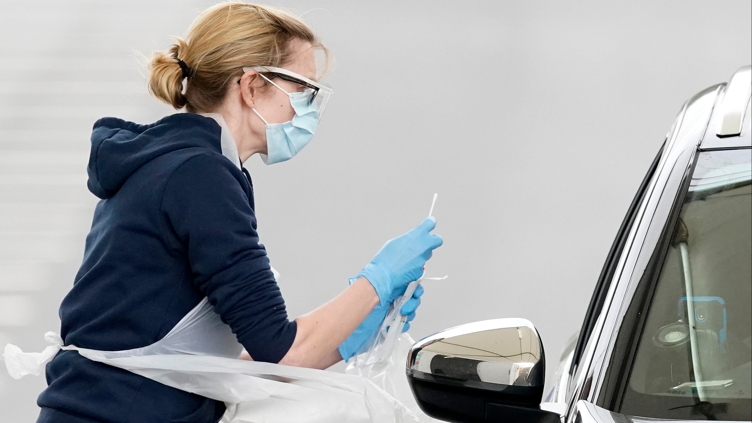 A nurse takes a swab at a Covid-19 Drive-Through testing station