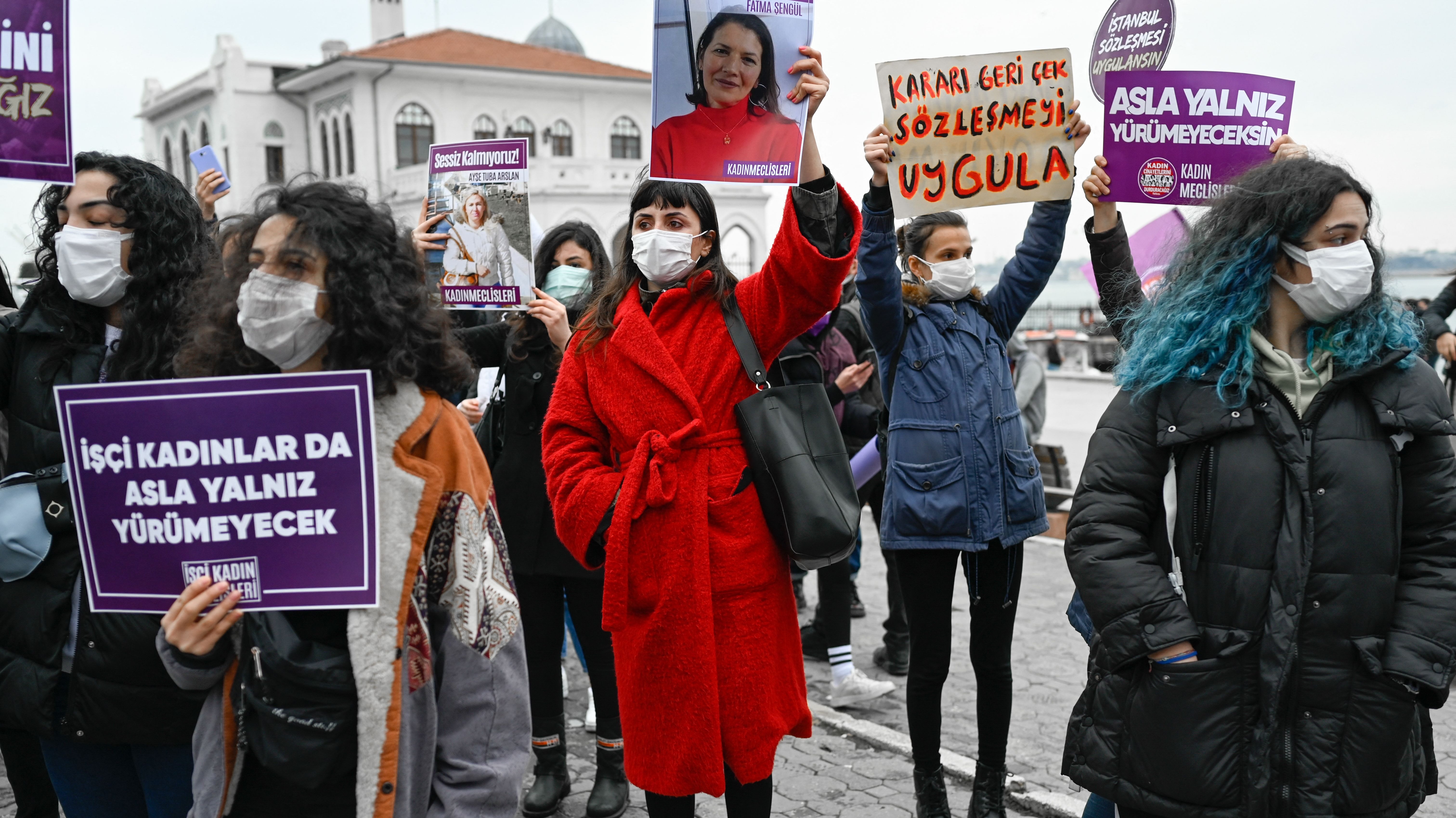 A protester holds a picture of a woman killed by a man, where it is reading "We won't be silent", during a demonstration against Turkey's withdrawal from Istanbul Convention.