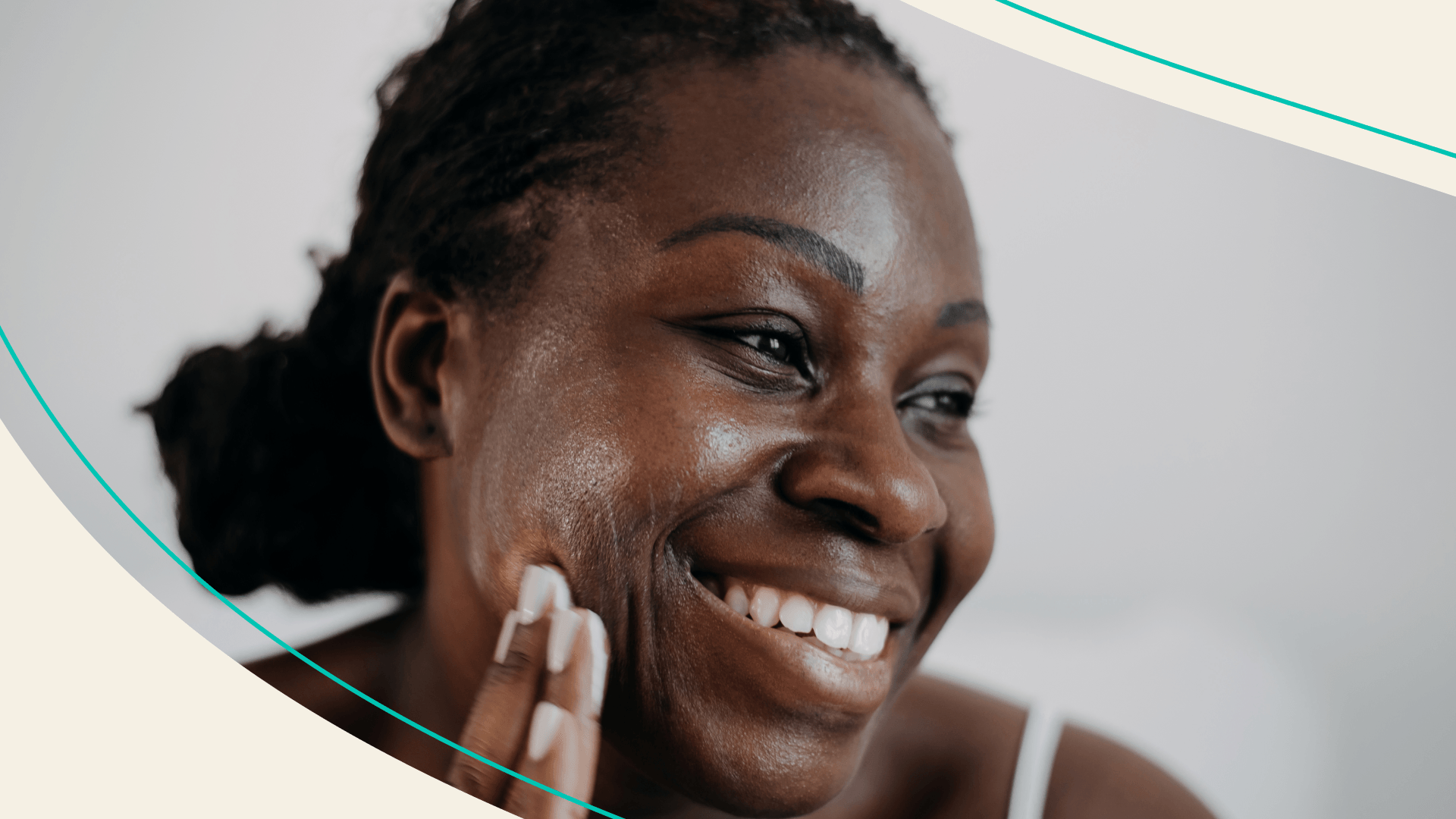A woman rubbing moisturizer on her check
